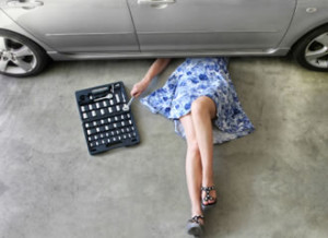 vrouw onder auto in garage