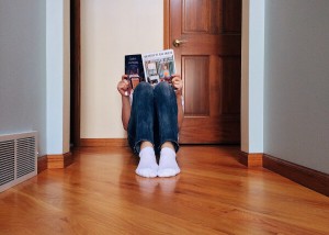 Young person reading magazine while sitting on the floor