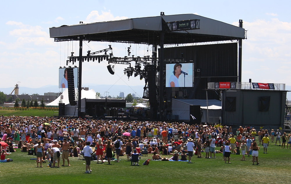 Stage of music festival with people on the field outside