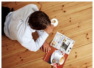 Man reading magazine on floor