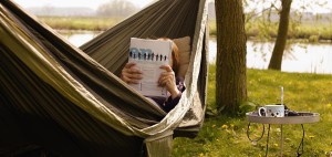 Person reading magazine in hammock