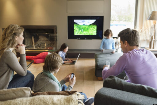 family in living room using different media